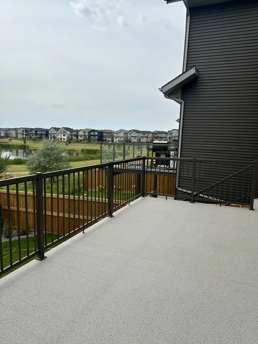 Deck with black aluminum railing overlooking a pond, Edmonton — TrueBlue Builders